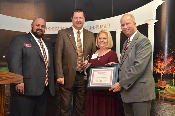 Lindy Forbes, second from left, was named Campbellsville University’s 2016 Distinguished Alumna at the Homecoming Reception Oct. 14. Making the presentation was from left: Dr. Michael V. Carter, president; Benji Kelly, vice president for development, and Darryl Peavler, director of alumni relations. (CU Photo by Joan C. McKinney)