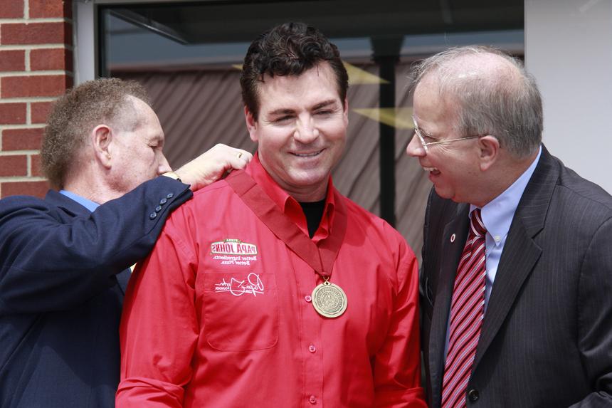 Dr. Michael V. Carter, left, and Dr. Frank Cheatham, right, present the Campbellsville University Leadership Award to  "Papa" John Schnatter during the grand opening. (Campbellsville University Photo by Rachel DeCoursey)